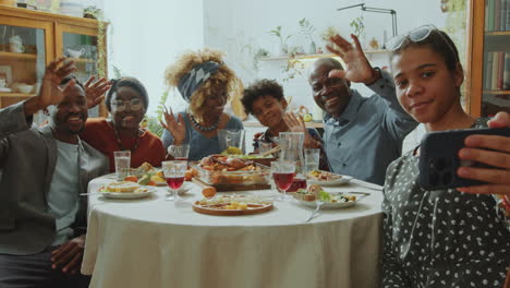teen girl taking selfie with cheerful family on holiday dinner at home