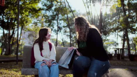 Mother and daughter having a conversation on a park bench