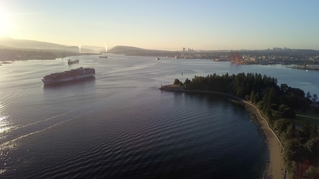 캐나다 브리티시 컬럼비아주 밴쿠버의 스탠리 공원 근처 일출에 버라드 입구를 가로질러 항해하는 화물선