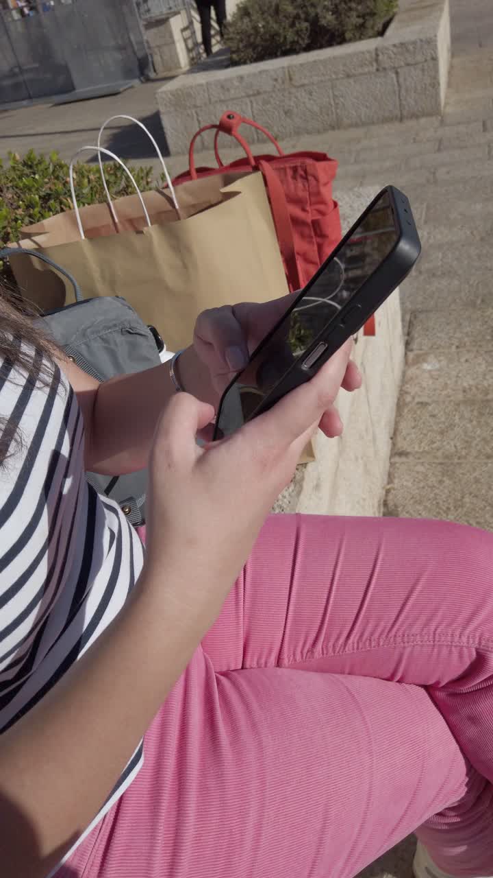 mujer usando el teléfono mientras está sentada en un banco