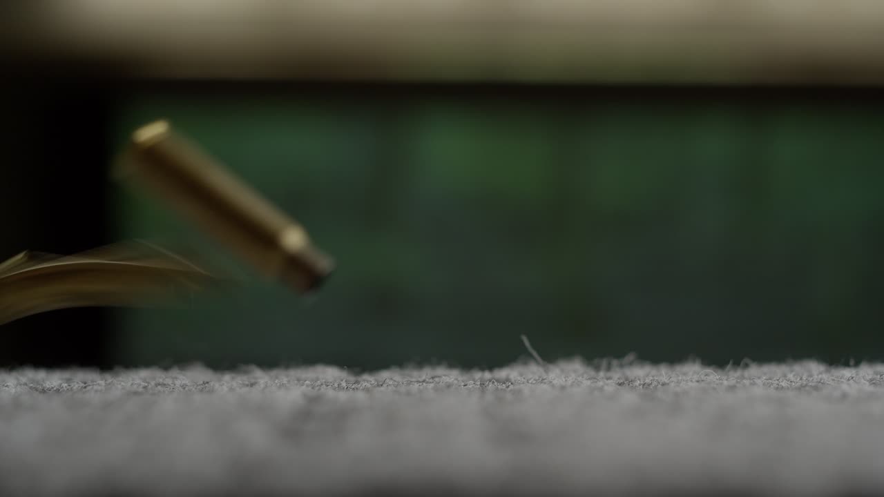 Empty bullet shells fall down raining after firing gun at shooting range, slow motion from close up