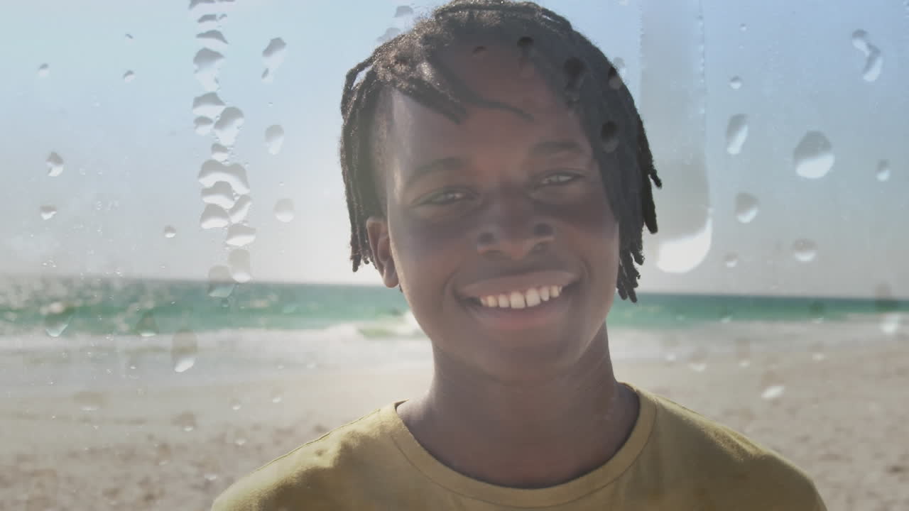 Animation av en leende afroamerikansk man på en solig strand över vattendroppar