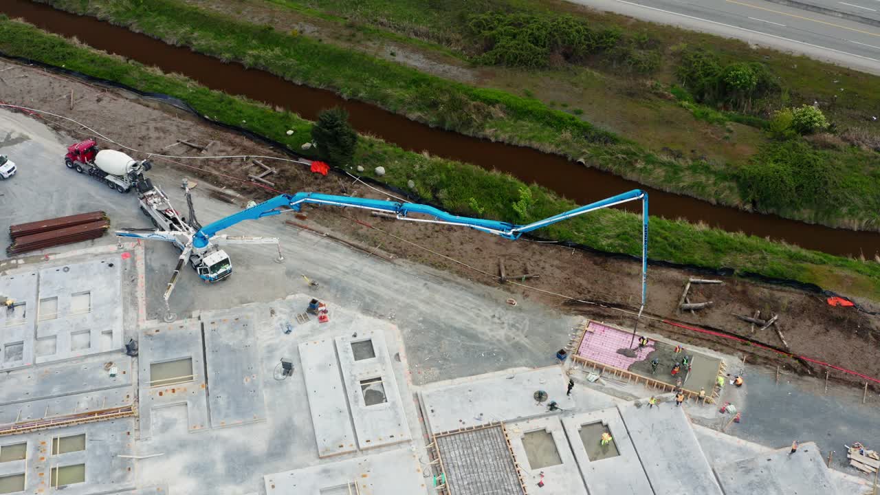bomba de pluma de hormigón montada en un camión que vierte mezcla de hormigón en el sitio de fabricación de elementos prefabricados