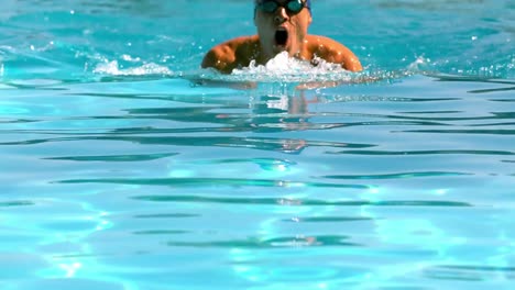 Nadador-En-Forma-Haciendo-El-Estilo-Mariposa-En-La-Piscina.