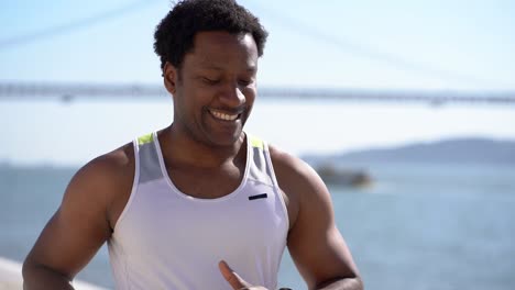 smiling young man jogging at riverside