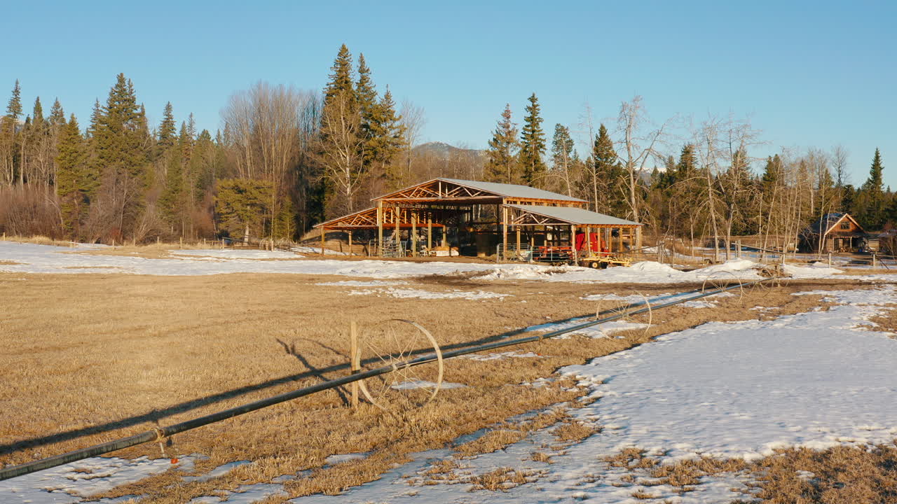 Orbita aerea di un fienile da un campo agricolo invernale con irrigatori a ruota idraulica.