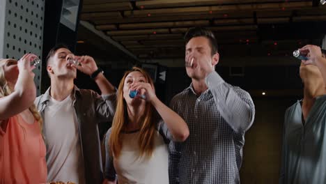group of friends toasting shot glasses of tequila