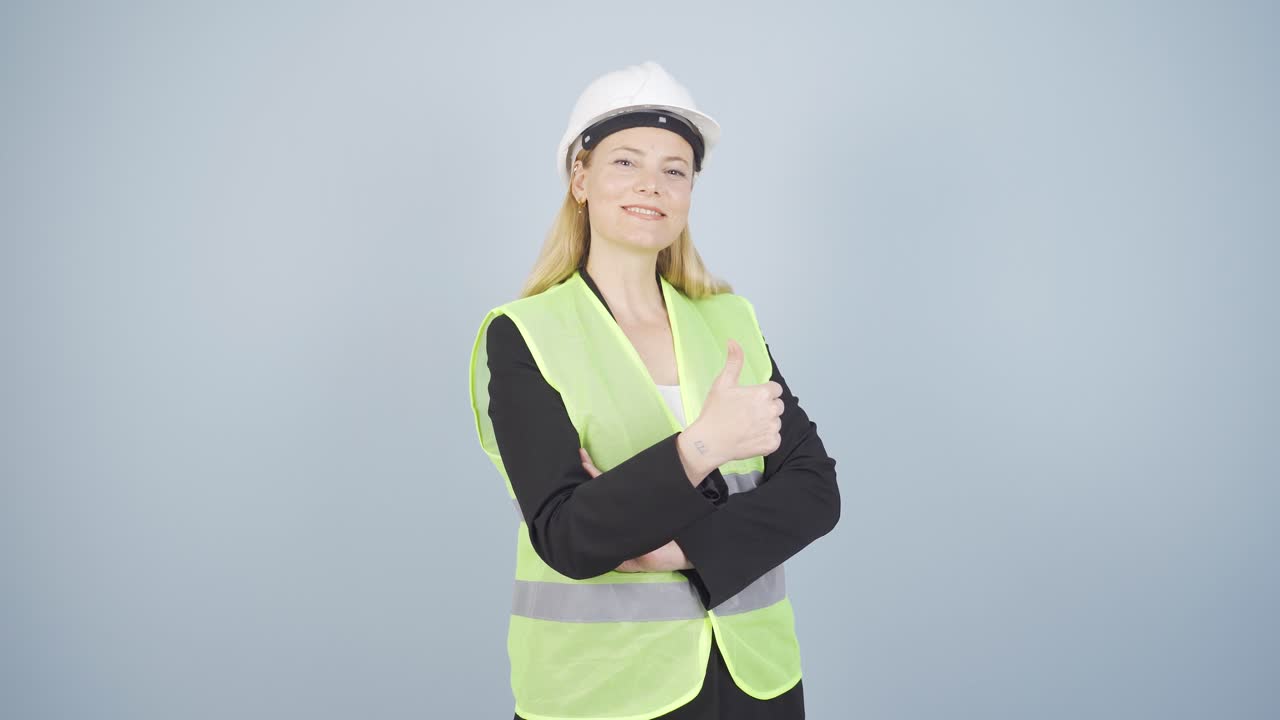 la ingeniera cruza los brazos y se ríe de la cámara.