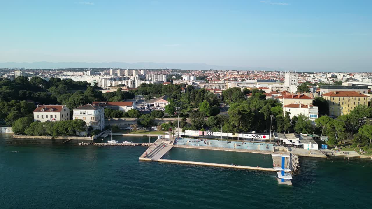 panorama costero desde arriba con piscina de mar y plataforma de buceo, nadadores y ciudad de zadar, croacia