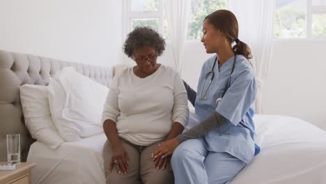 mixed race woman being visited at home by a nurse. social distancing and self isolation in quarantin