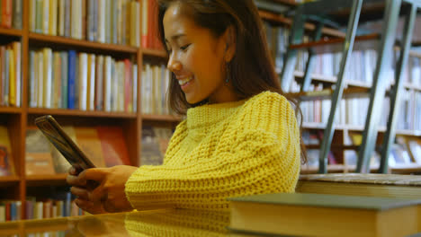 adolescente usando una tableta digital en la biblioteca 4k