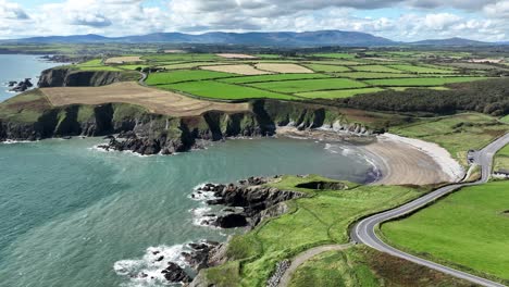 Coast-of-Ireland-static-shot-of-The-Copper-Coast-Road-Waterford-dropping-to-Kilmurrin-Cove-with-the-Majestic-Comeragh-Mountains