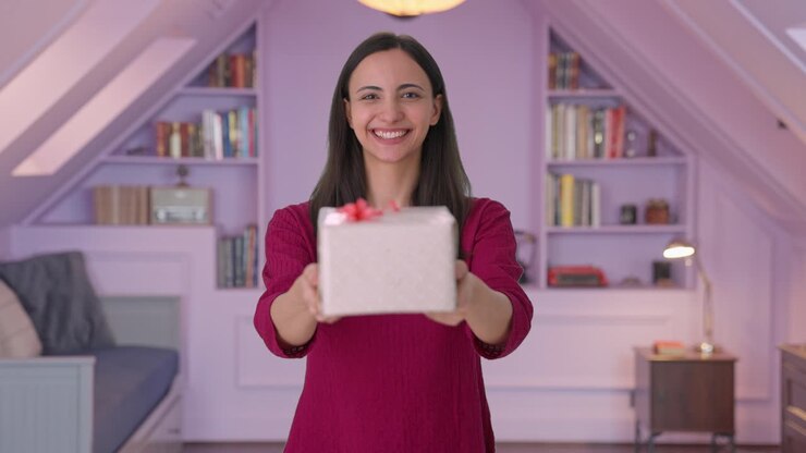 mujer india feliz dando un regalo