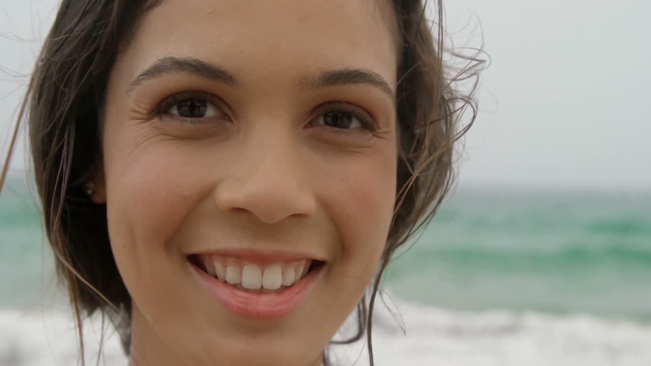 vista frontal de una mujer caucásica de pie en la playa 4k