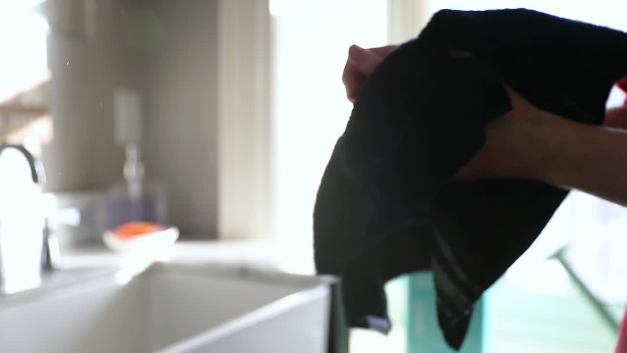 hombre secándose las manos después de lavarse en un baño soleado a cámara lenta