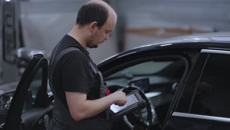 mecánico automotriz trabajando con una herramienta de diagnóstico de automóviles en un taller de reparación. el gerente de servicio de automóviles o mecánico utiliza una tableta con un software de diagnóstico interactivo futurista.