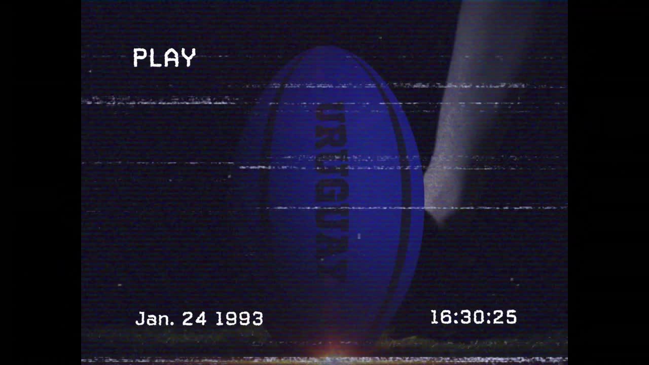 VHS play appearing, cleated foot striking rotating rugby ball, sending ball flying showing power