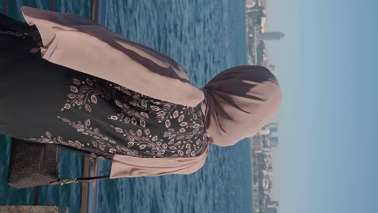Donna con hijab vicino al mare