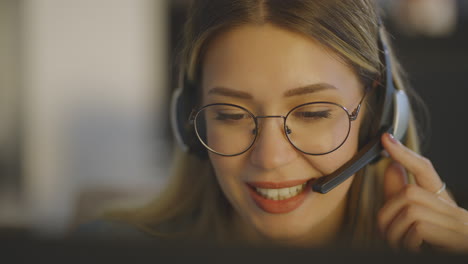mujer trabajando en la computadora con auriculares
