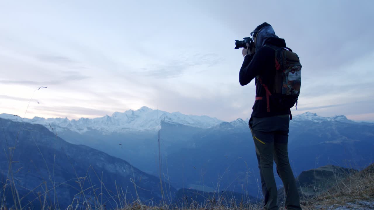 excursionista está tomando una fotografía desde la cima de una montaña con mt-blanc en el fondo