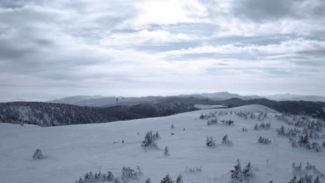 Kite-skiing-on-a-mountain-in-winter---aerial-orbit-view