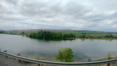 punto de vista del pasajero mientras conduce a lo largo del río okanogan, una zona agrícola de las tierras altas de okanogan en el centro norte del estado de washington