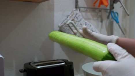 a cucumber is peeled with a potato peeler