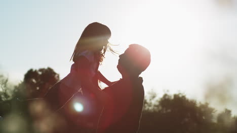 padre e hija jugando al aire libre al atardecer