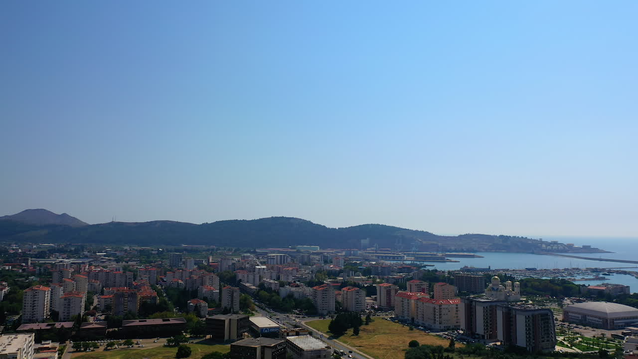 Panorama of Bar, Montenegro at the Adriatic shore. Scenic view of the city limited by mountains on sunny day. Aerial view.