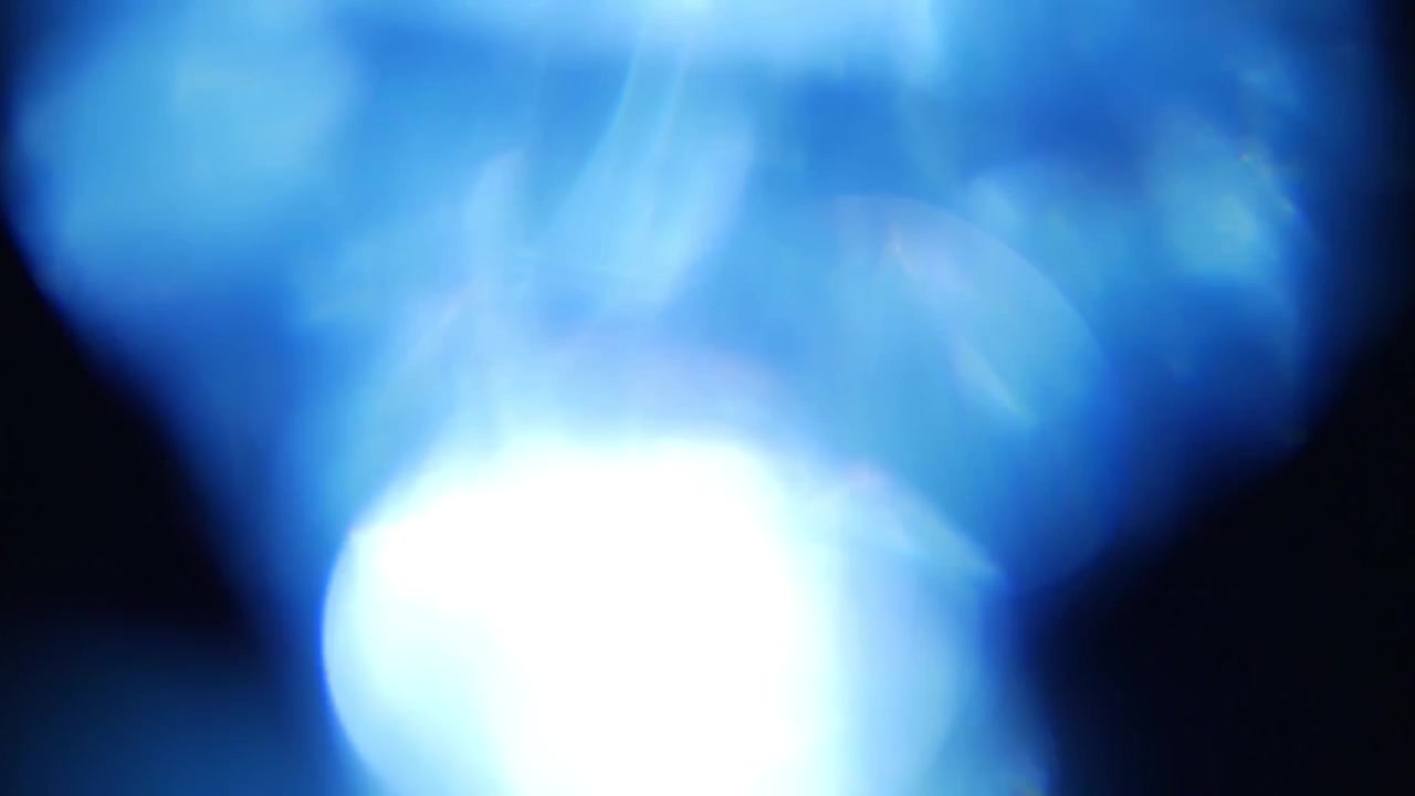 Fughe di luce blu dinamiche e bagliori dell'obiettivo su sfondo nero