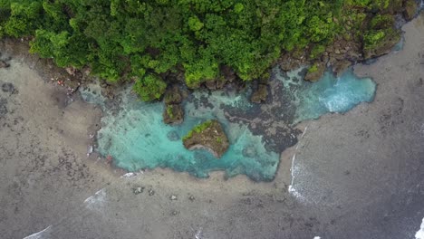 Corriente-Marina-En-Piscinas-De-Rocas-Magpupungko-Con-Gente-Nadando-En-Agua-Azul-Clara