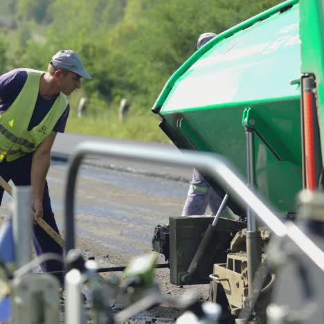 professional machine for compacting and leveling of soil rides along the road under workers control