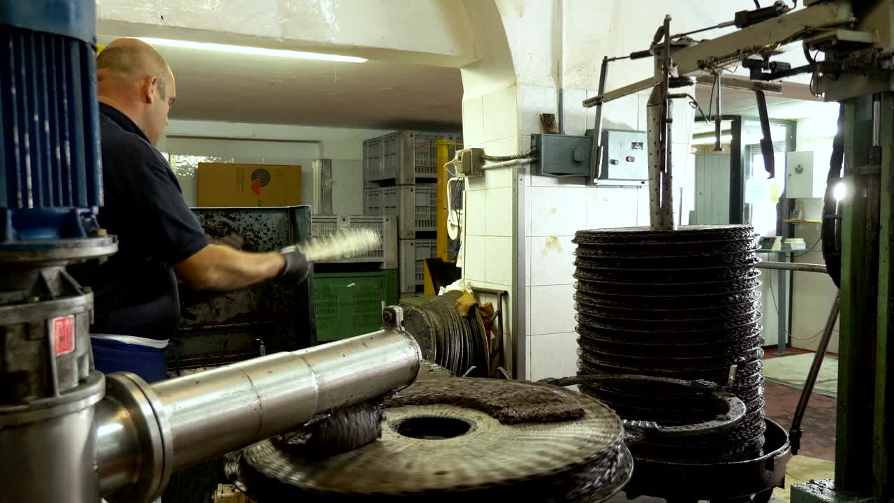 agricultor que trabaja en un molino de aceite de oliva en el sur de italia