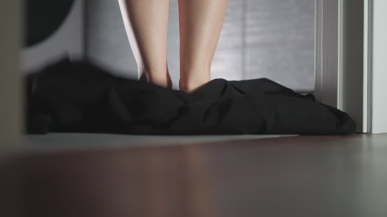 발바닥이 벗겨진 여자와 화장실에서 옷을 벗고 떨어지는 우아한 여인이 실크 로브를 벗고 집에서 욕조에 들어갑니다.