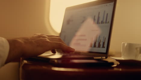 closeup hands touching touchpad on laptop. manager working on computer graphs