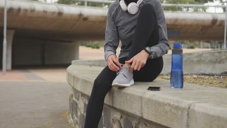 woman wearing hijab tying her shoelaces