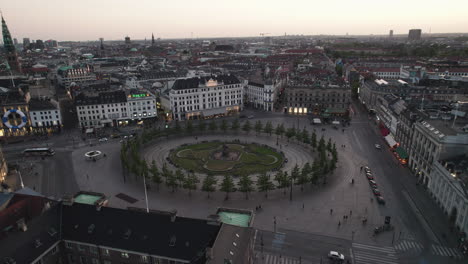 Vista-Aérea-De-Kongens-Nytorv-Y-Nyhavn-Por-La-Noche,-Llena-De-Gente-Y-Animada-Por-Las-Luces-Nocturnas-De-La-Ciudad