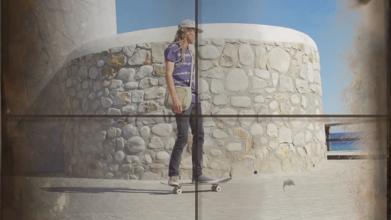 Video verticale: Skater che si spinge, scorre lungo un muro, su una ringhiera verso il mare per divertimento, con un film di viaggio che sfarfalla.