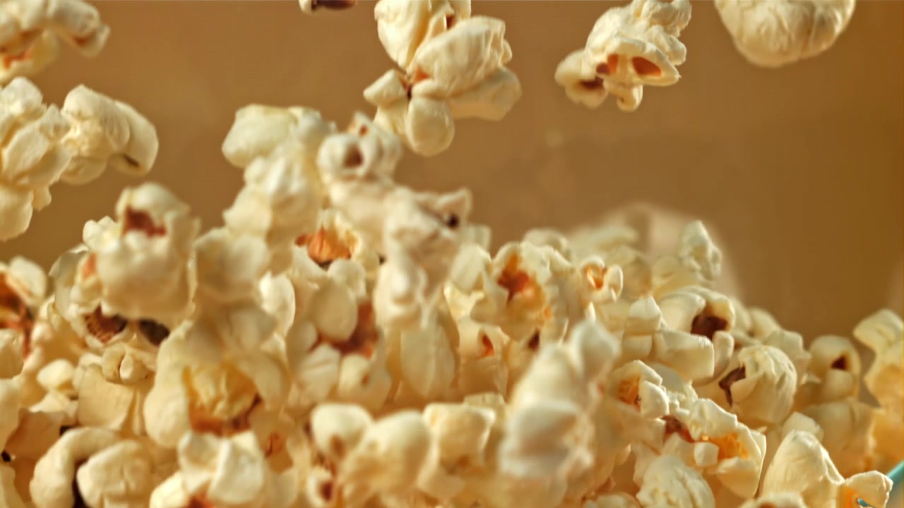 Popcorn che cadono in una ciotola di vetro al rallentatore