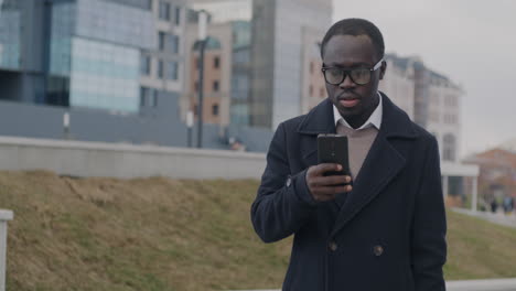 man looking at smartphone in city