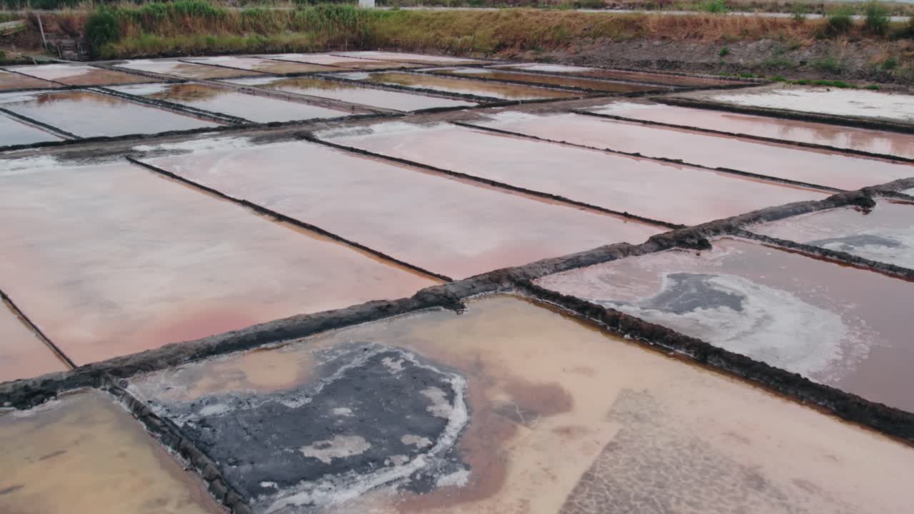 aerial Aveiro’s historic salt flats with pink and white geometric ponds under natural light, Portugal