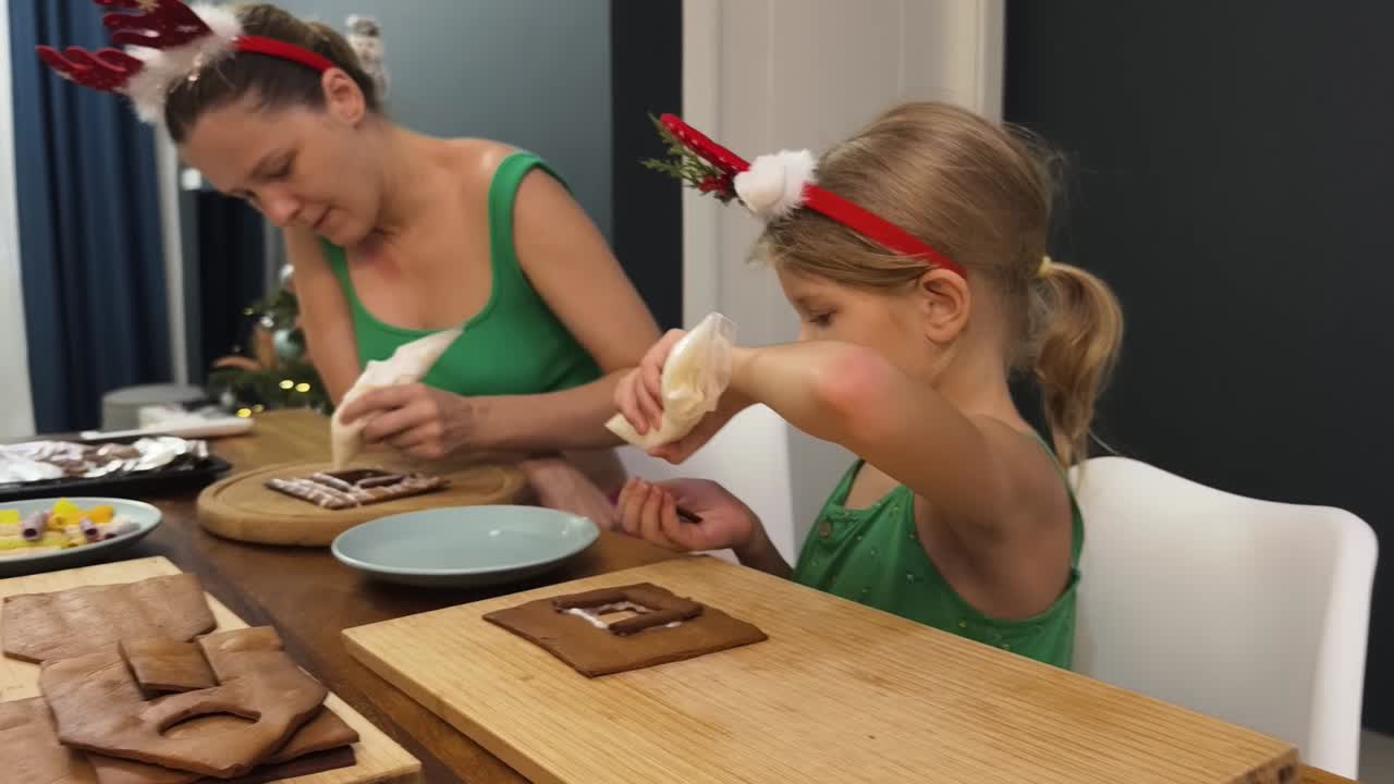 madre y hija decorando casas de pan de jengibre