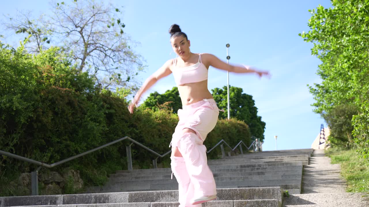 Woman Dancing on Stairs in Pink Outfit