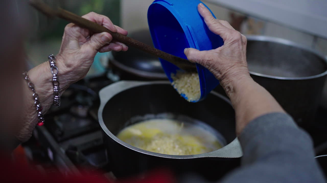 Bagna cauda cooking with basic ingredients by an elderly person of boiling water on stove