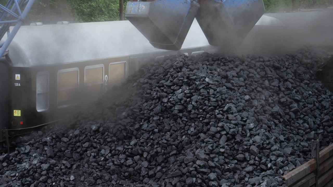 Still shot excavator loading coal to cargo container to steam locomotive engines