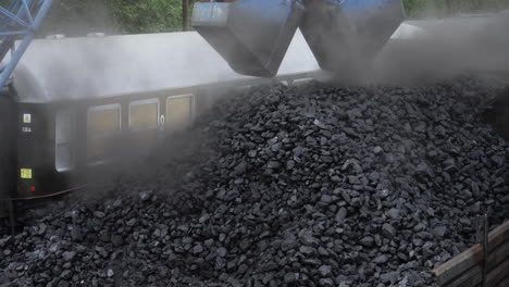 still shot excavator loading coal to cargo container to steam locomotive engines