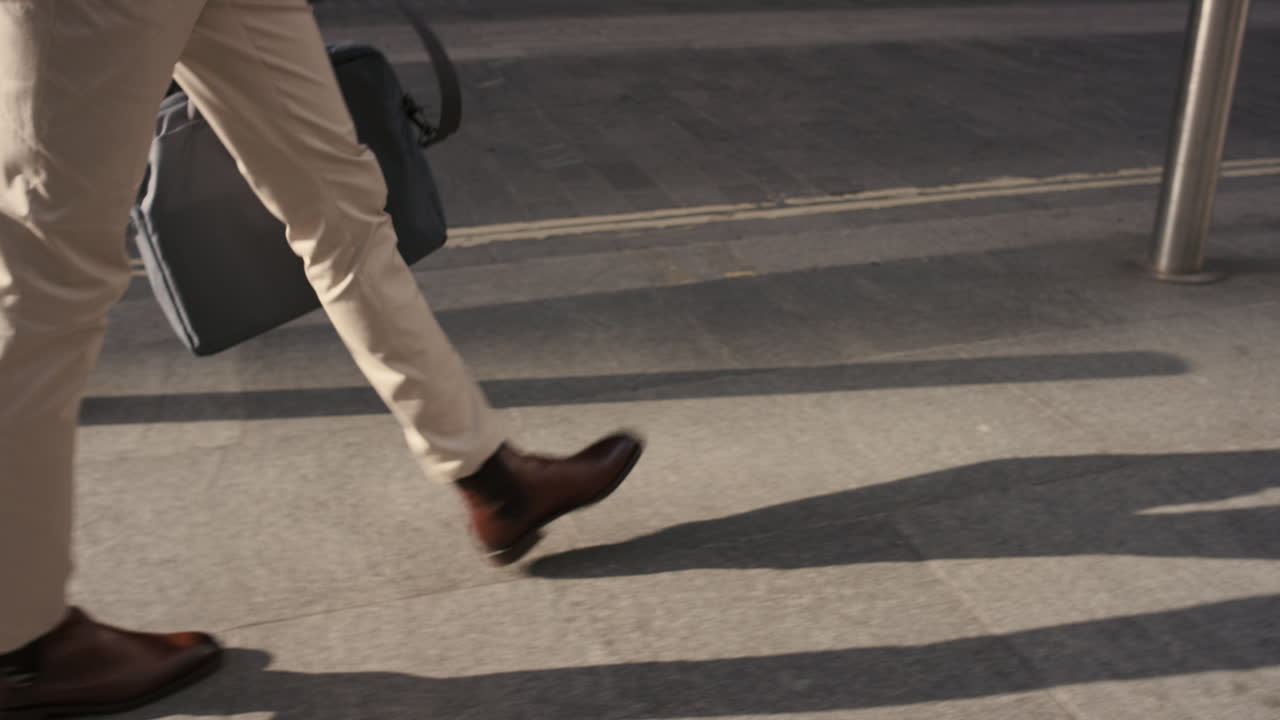 Primo piano dei piedi di un uomo d'affari che cammina in città.