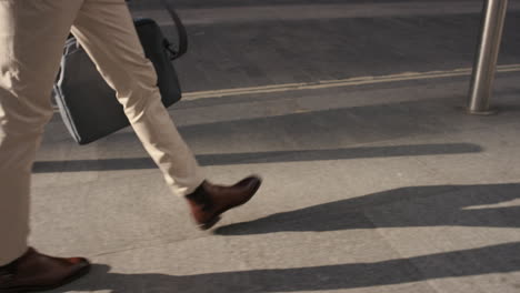 cosecha cercana de pies de hombre de negocios caminando por la ciudad