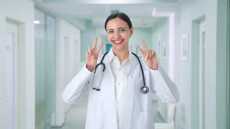 happy indian female doctor showing victory sign