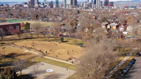 gran antena sobre un parque para perros y dueños de mascotas para revelar el horizonte del centro de denver colorado 1